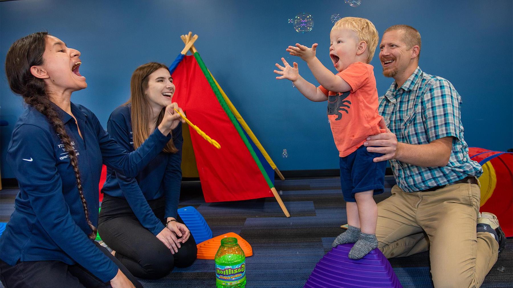 Students working with a young patient in occupational therapy.